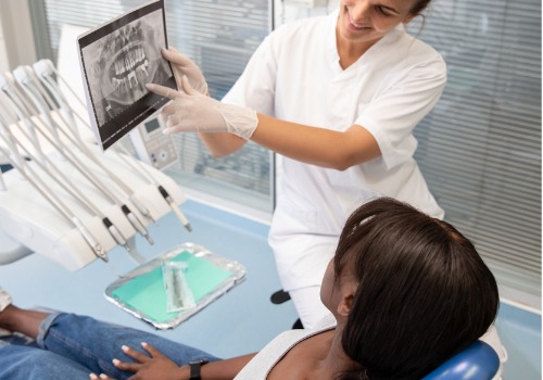 A dental patient is shown an X-ray of her mouth. Associates in Dentistry is a dentist in Peoria IL.