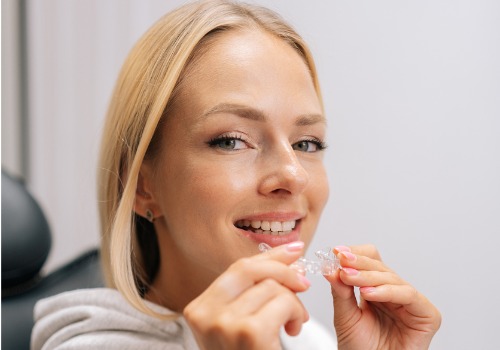 A woman is seen preparing to snap in her clear aligners. Associates In Dentistry offers Invisalign in Peoria IL.