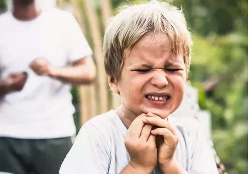 A chid is seen reacting to dental pain. Associates in Dentistry offers Emergency Dental Care.