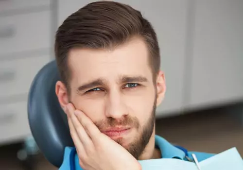 A man with a painful tooth is seen. Associates In Dentistry offers Emergency Dental Care in Washington IL.