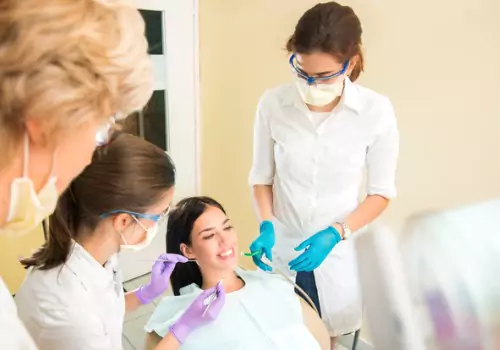 A woman is seen receiving dental care. Associates In Dentistry is a nearby dentist in Washington IL.