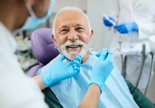 A man is seen receiving dental care. Associates In Dentistry is a nearby dentist in Canton.