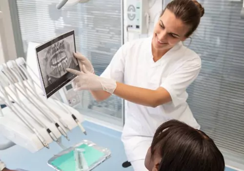 A dental worker is seen with a patient in a dental office. Associates In Dentistry is a Local Dentist in Peoria IL.