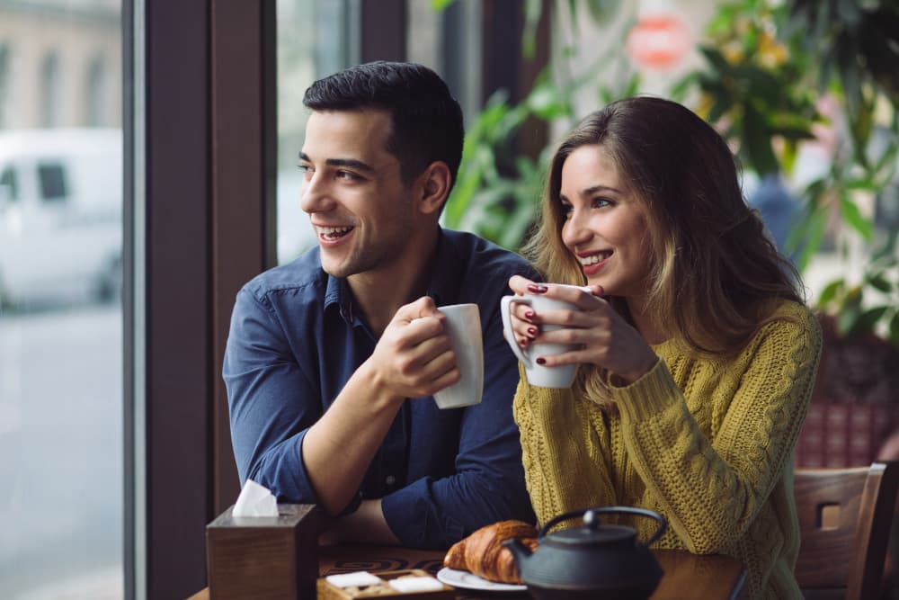 Smiling adult using a straw to drink iced coffee at home, showing bright teeth after whitening treatment in Canton, IL, and demonstrating stain-prevention habits.