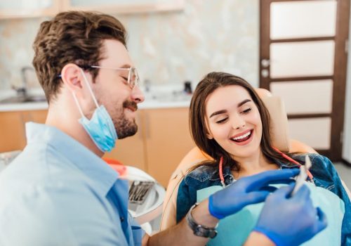 Smiling patient in a modern dental office receiving professional teeth whitening treatment from a cosmetic dentist in Canton, IL.