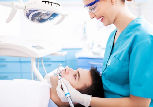 Image of Smiling patient receiving cosmetic dentistry care at Associates in Dentistry in Dunlap, IL, showcasing a healthy, confident smile in a modern dental office.